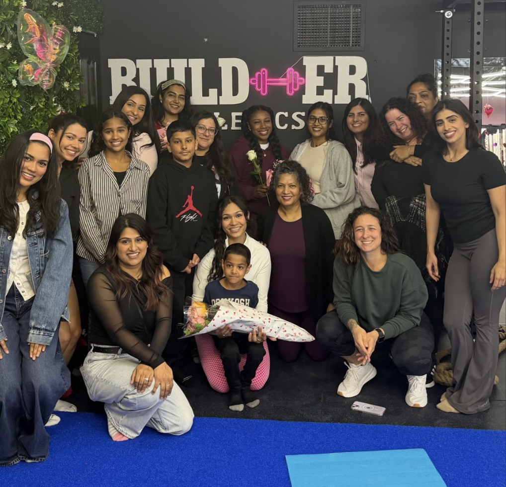 BuildHer Athletics members and coach posing together in the studio